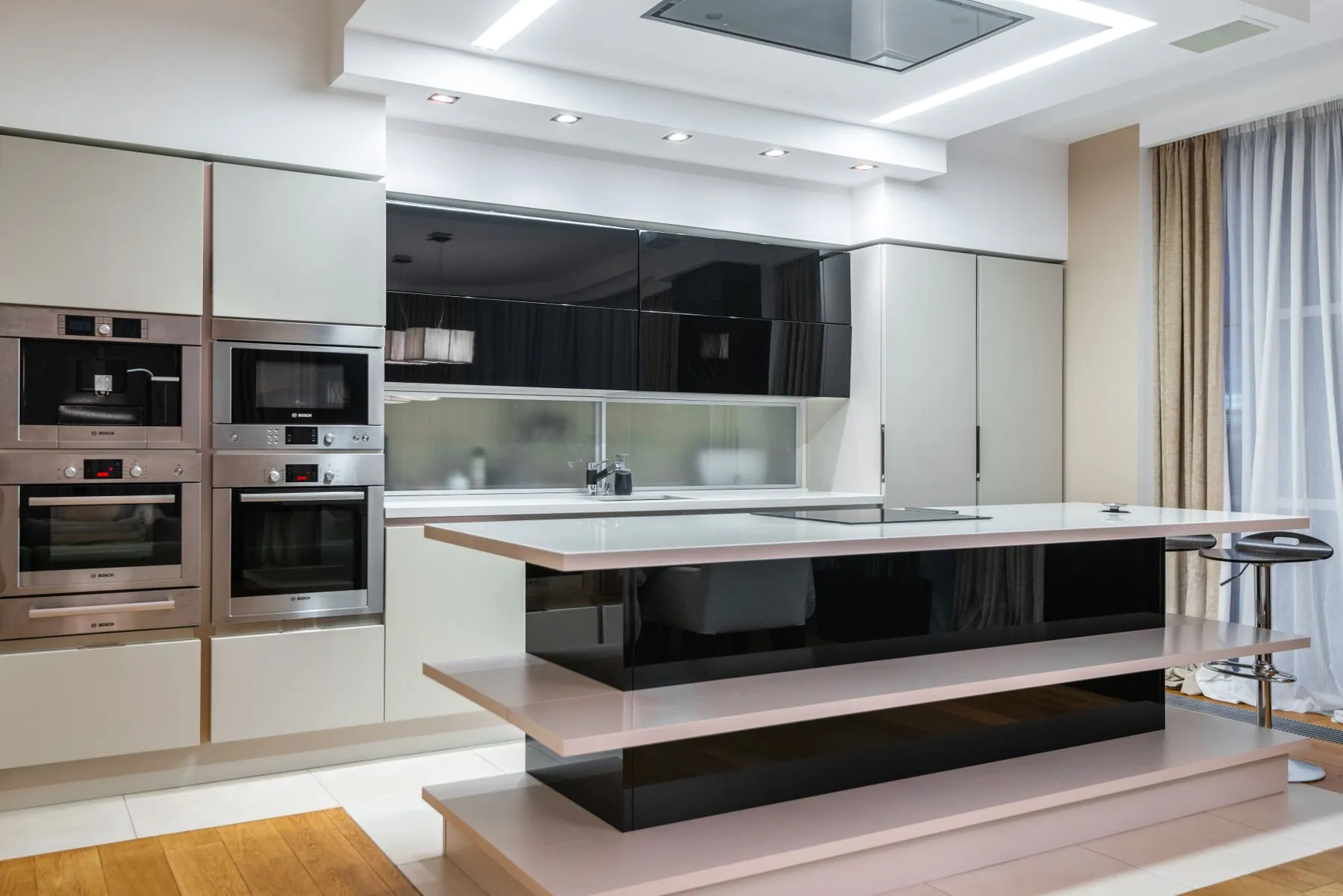 A run of flat-panel kitchen cabinetry with square-edged doors and a pale stone counter