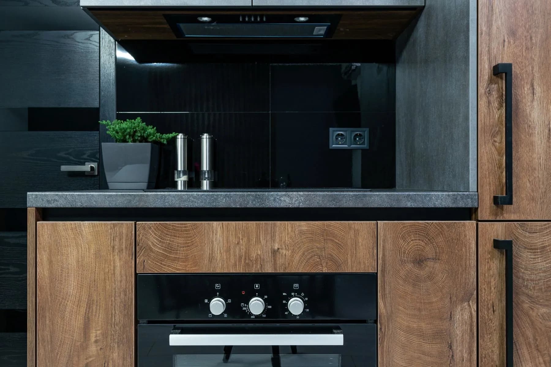 A modern kitchen with painted cabinetry, quartz counters and brushed brass hardware