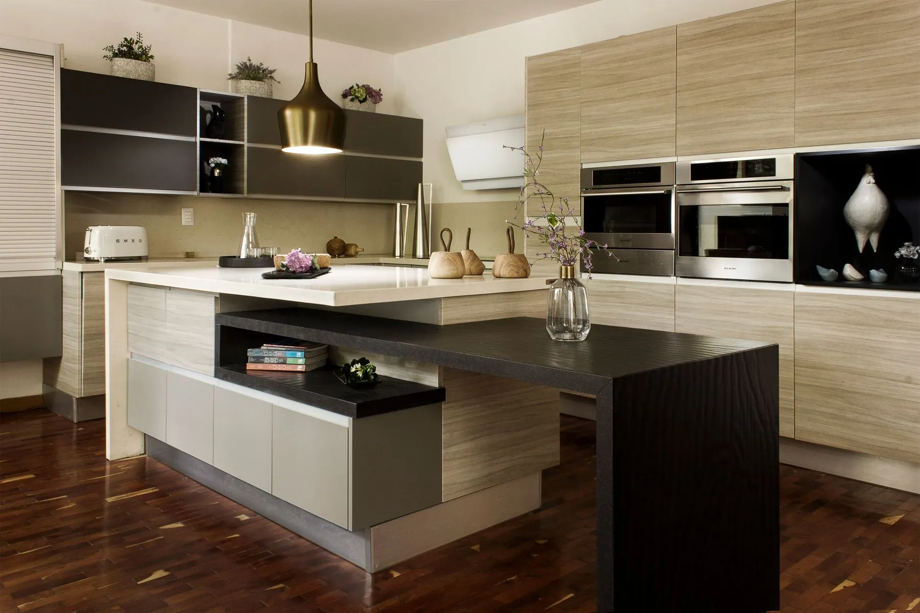 Deep drawers running under a stone counter in a modern kitchen with panelled appliances