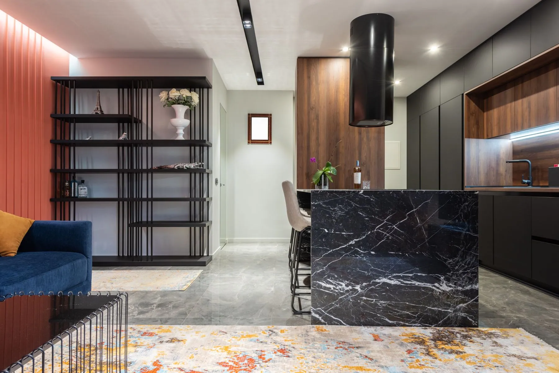 A marble island lit by a continuous line of light under the wall cabinets