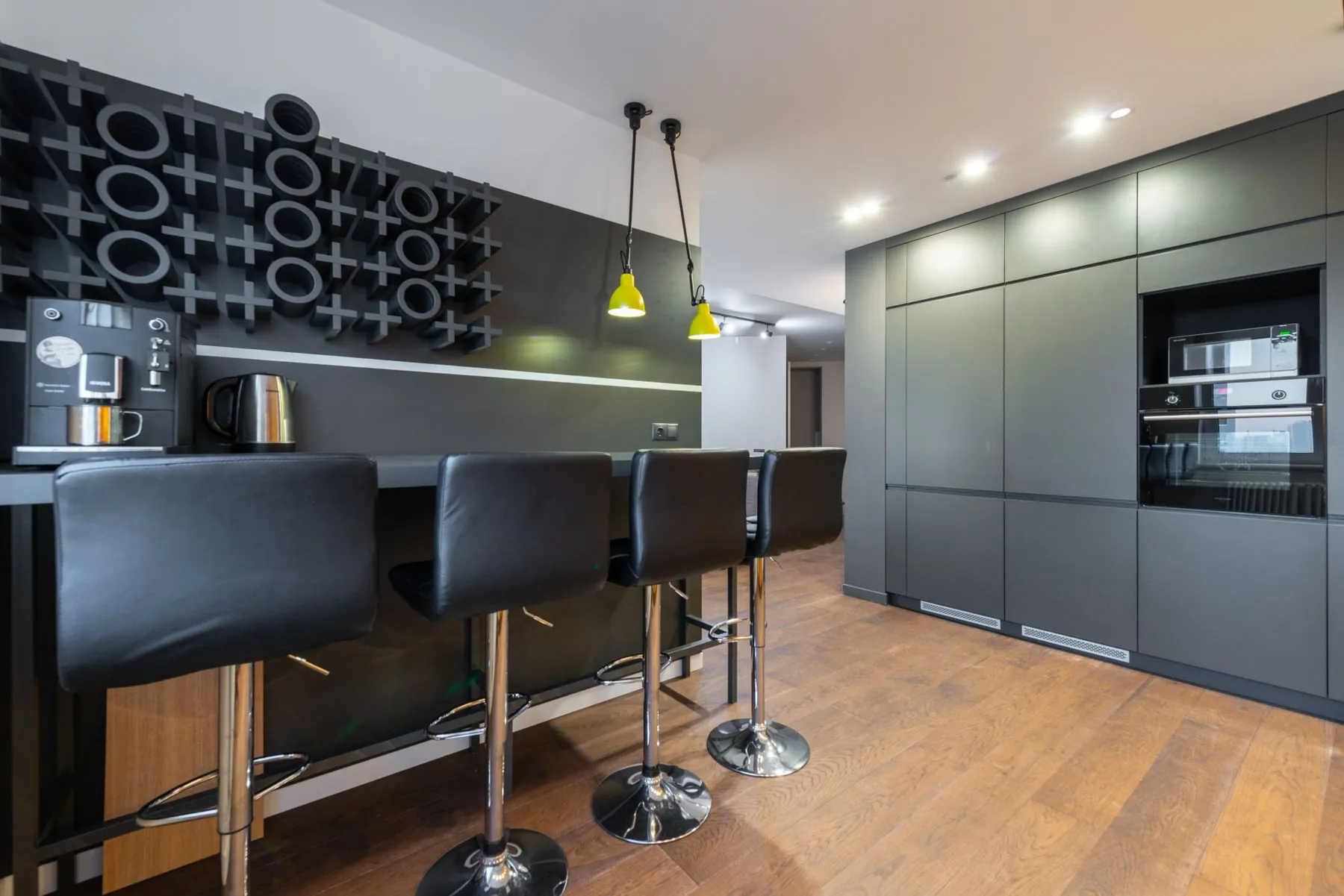 Dark cabinetry with tight, even reveals between doors, drawer fronts and a panelled appliance