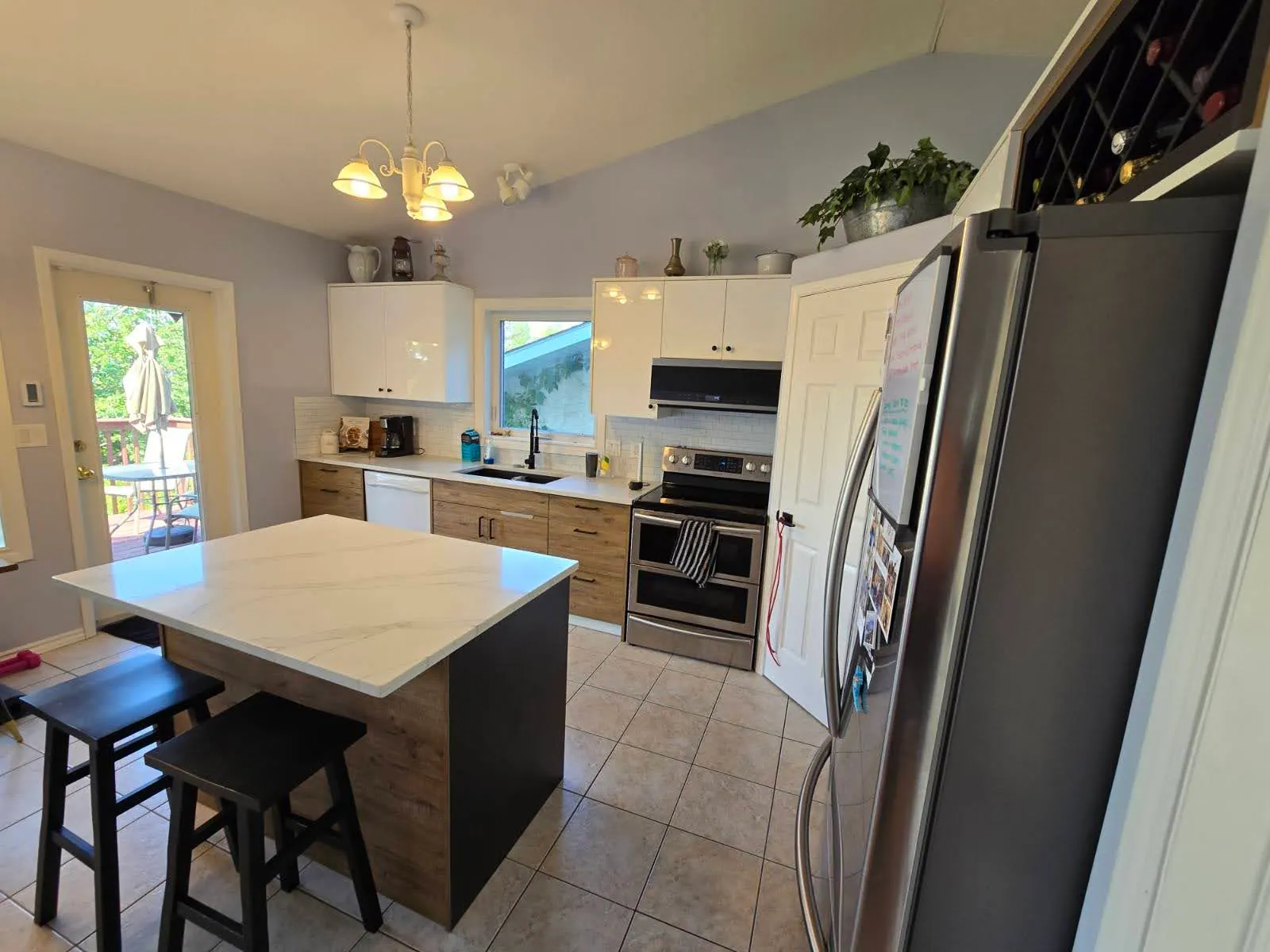 Tall bank beside a stainless refrigerator with wine storage built in above