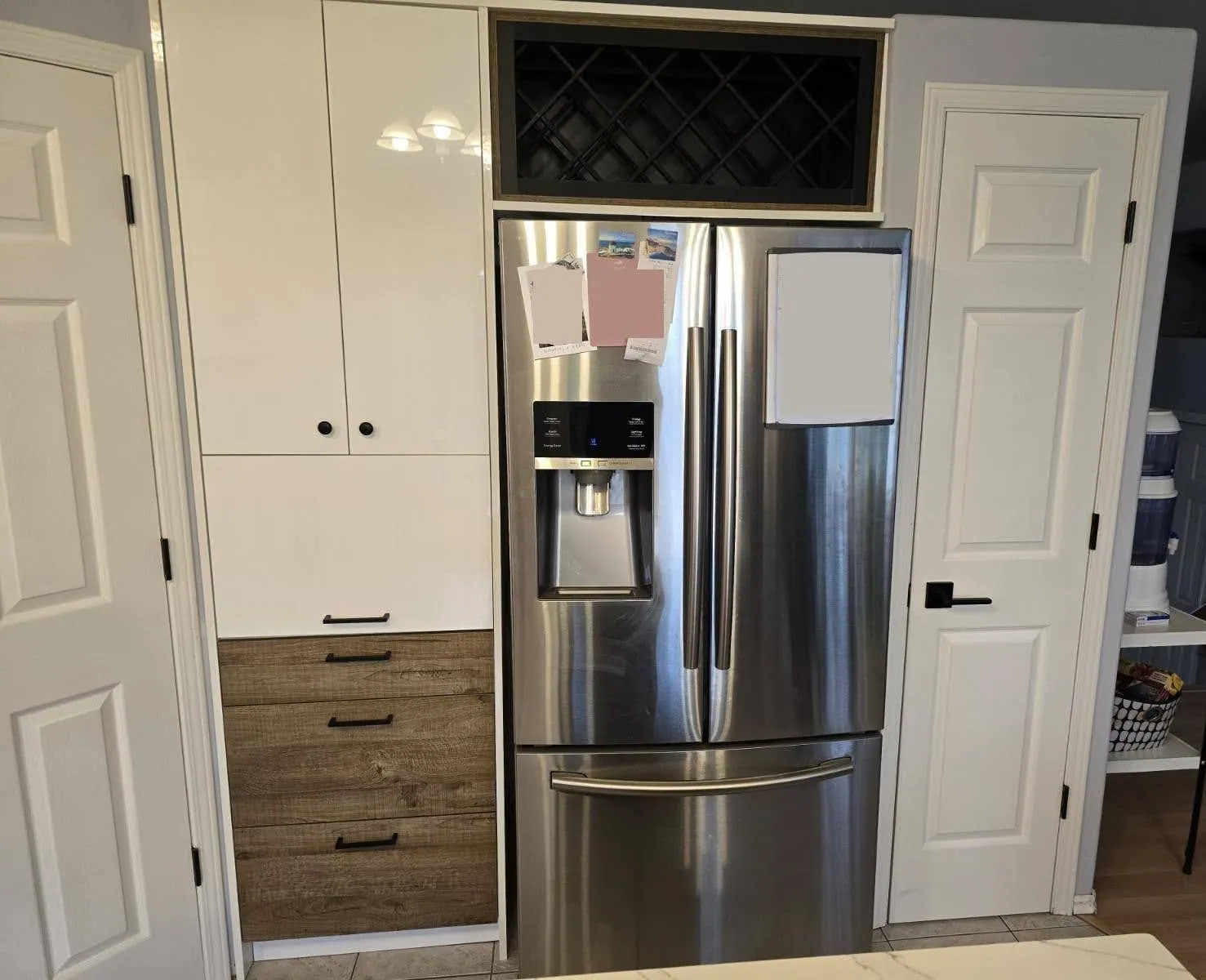 White wall cabinets and oak-look drawer banks meeting the quartz counter