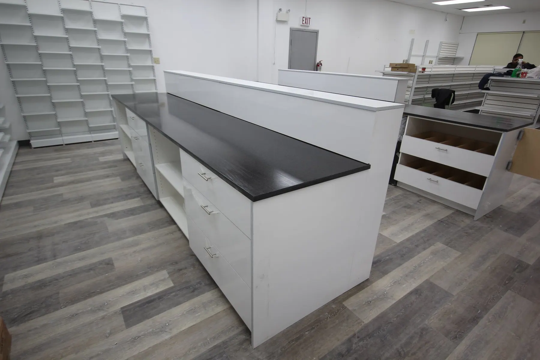 Dispensary benching in white slab with dark counters and drawer banks under