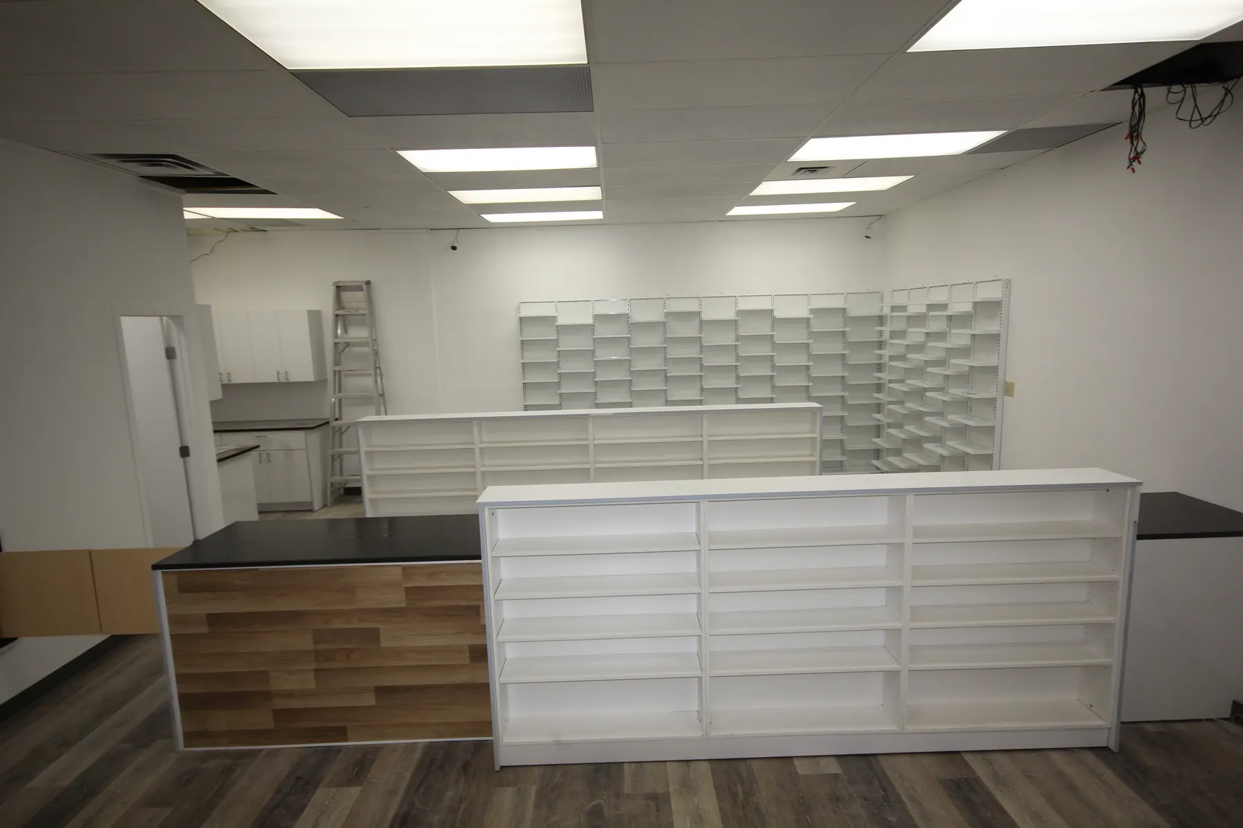 Wall of pigeonhole prescription shelving behind the dispensing bench