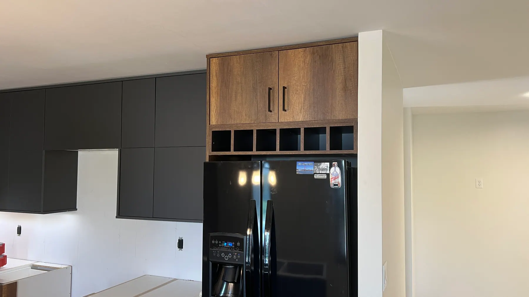 Open display niche built into the tall bank, lined in the same woodgrain as the fronts