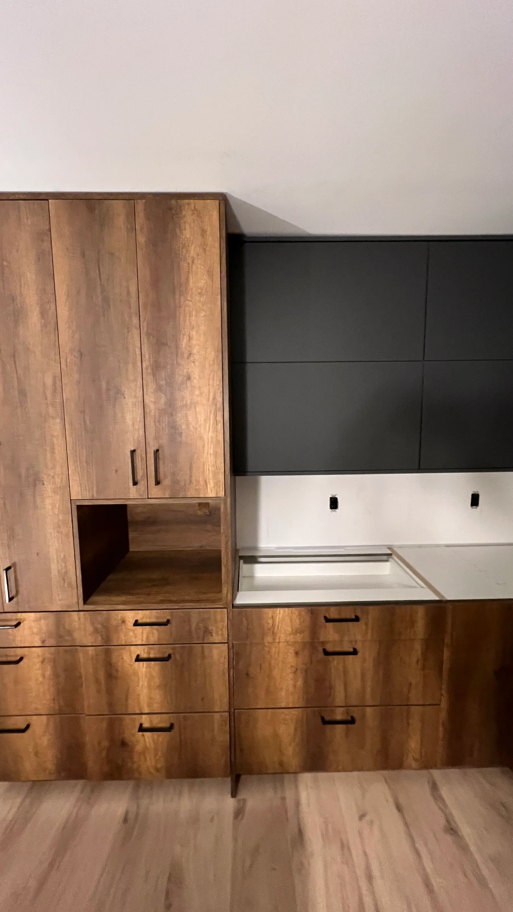 Island end panel in graphite matte meeting the light wood-look floor