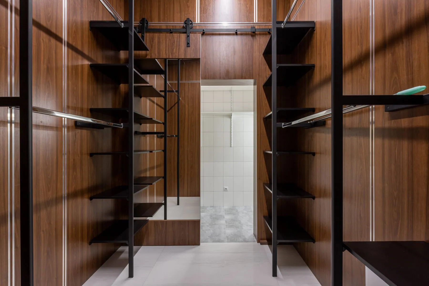 Floor-to-ceiling handleless wardrobe in warm white super-matte lacquer with slim sliding fronts and a recessed plinth
