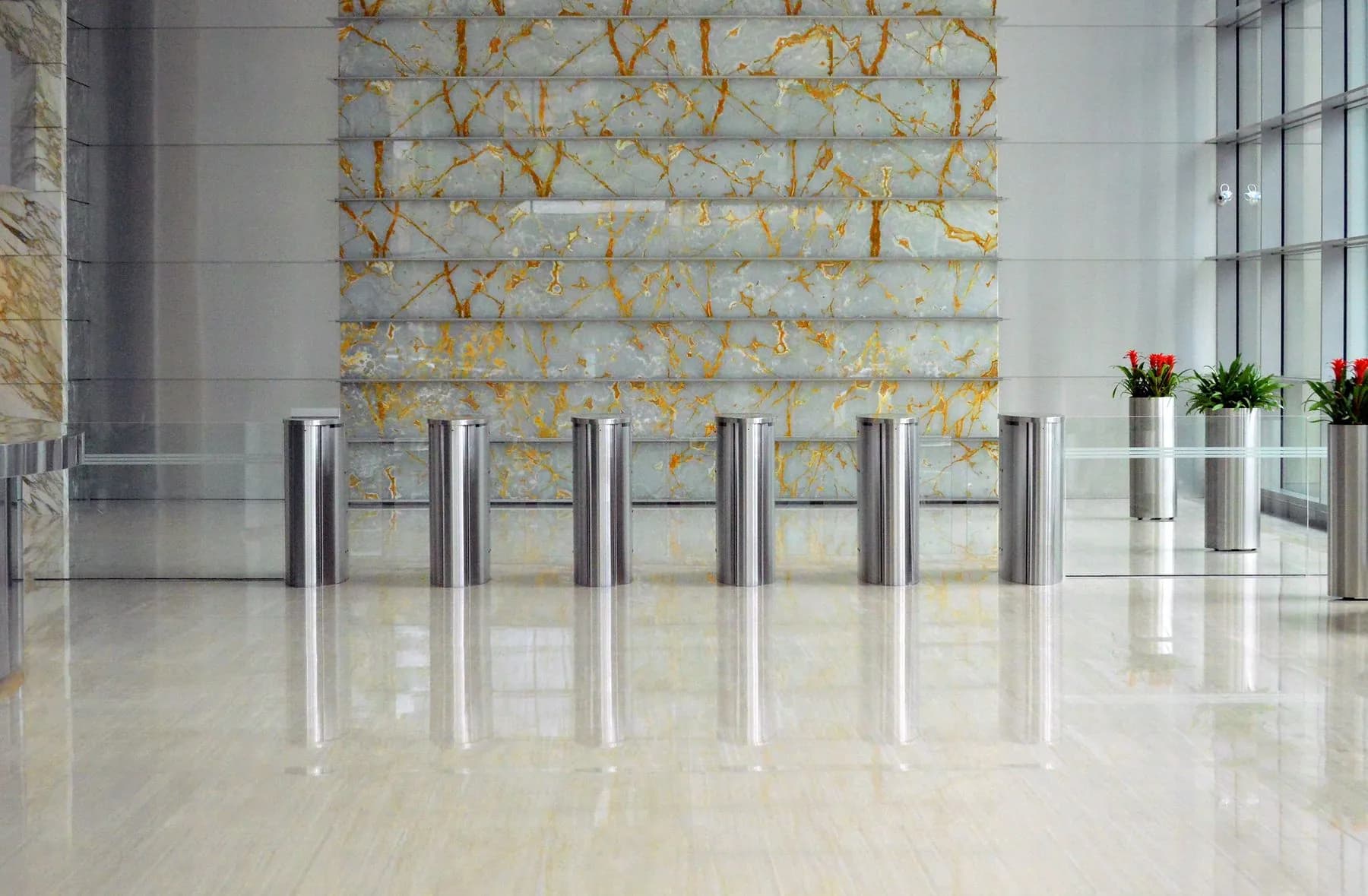 Office lobby faced in backlit stone panels with a polished floor and stainless entry line