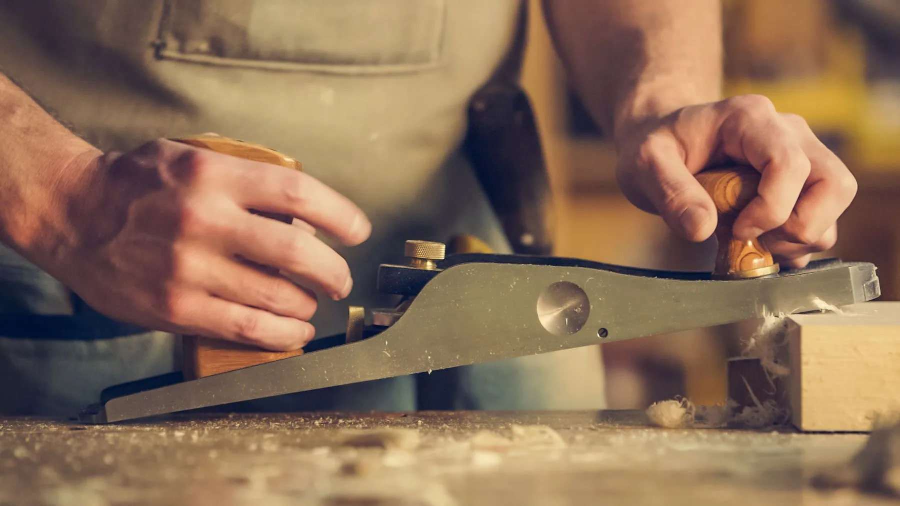 Cabinetmaker truing an edge with a hand plane at the bench