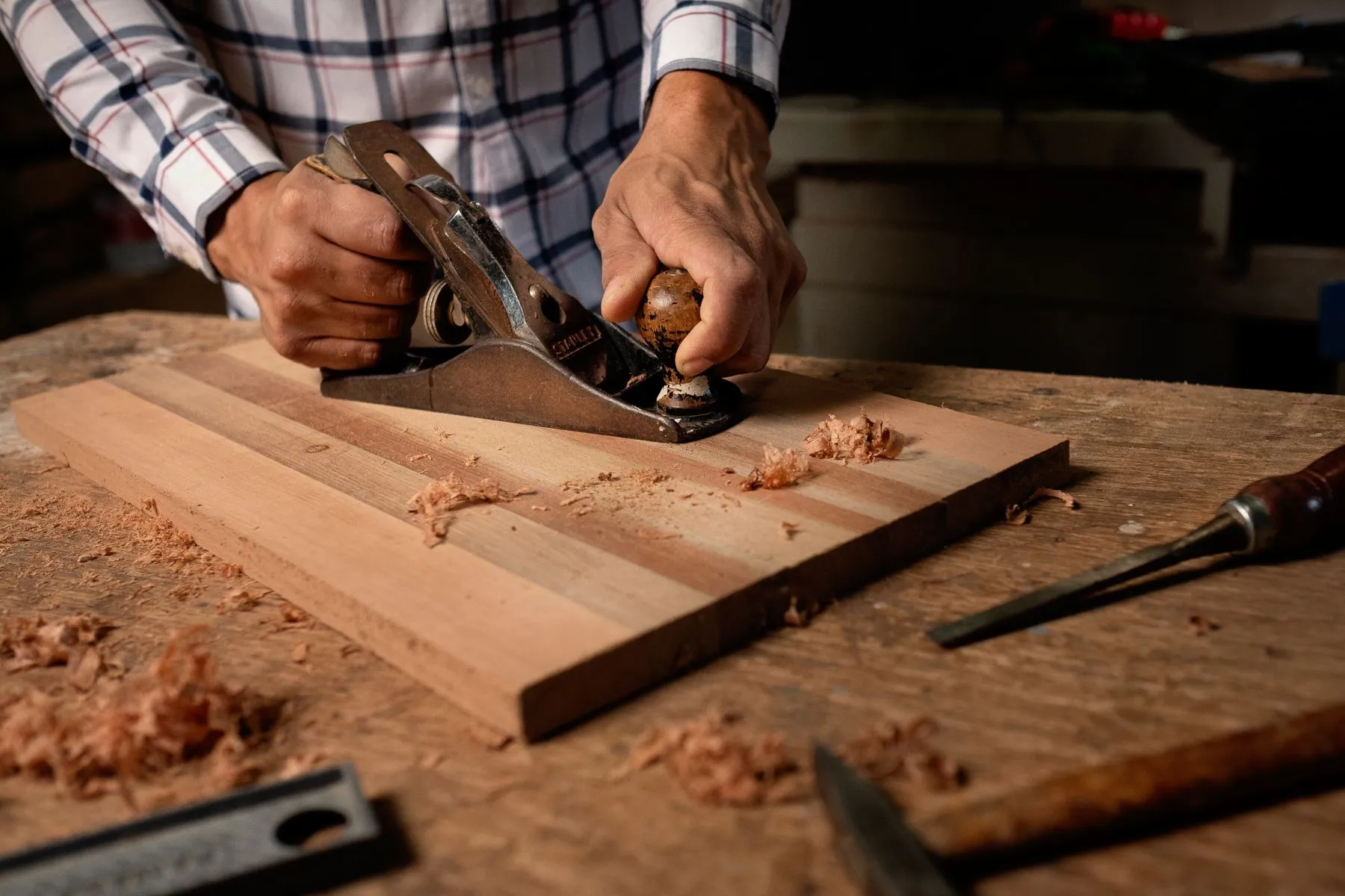 Truing an edge by hand at the bench before a panel goes through the machine