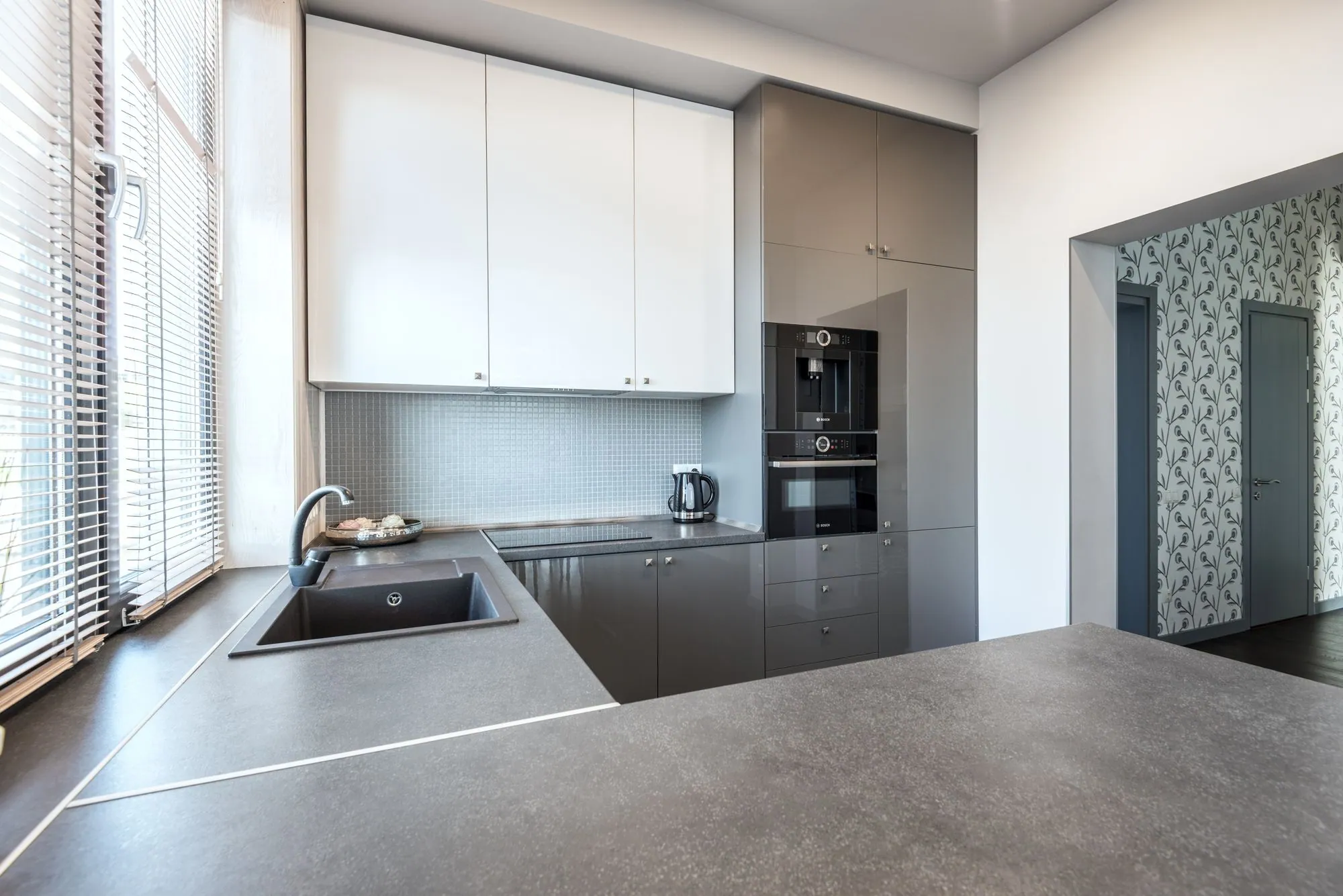 High-gloss grey tall bank with an integrated coffee machine and oven behind flush fronts