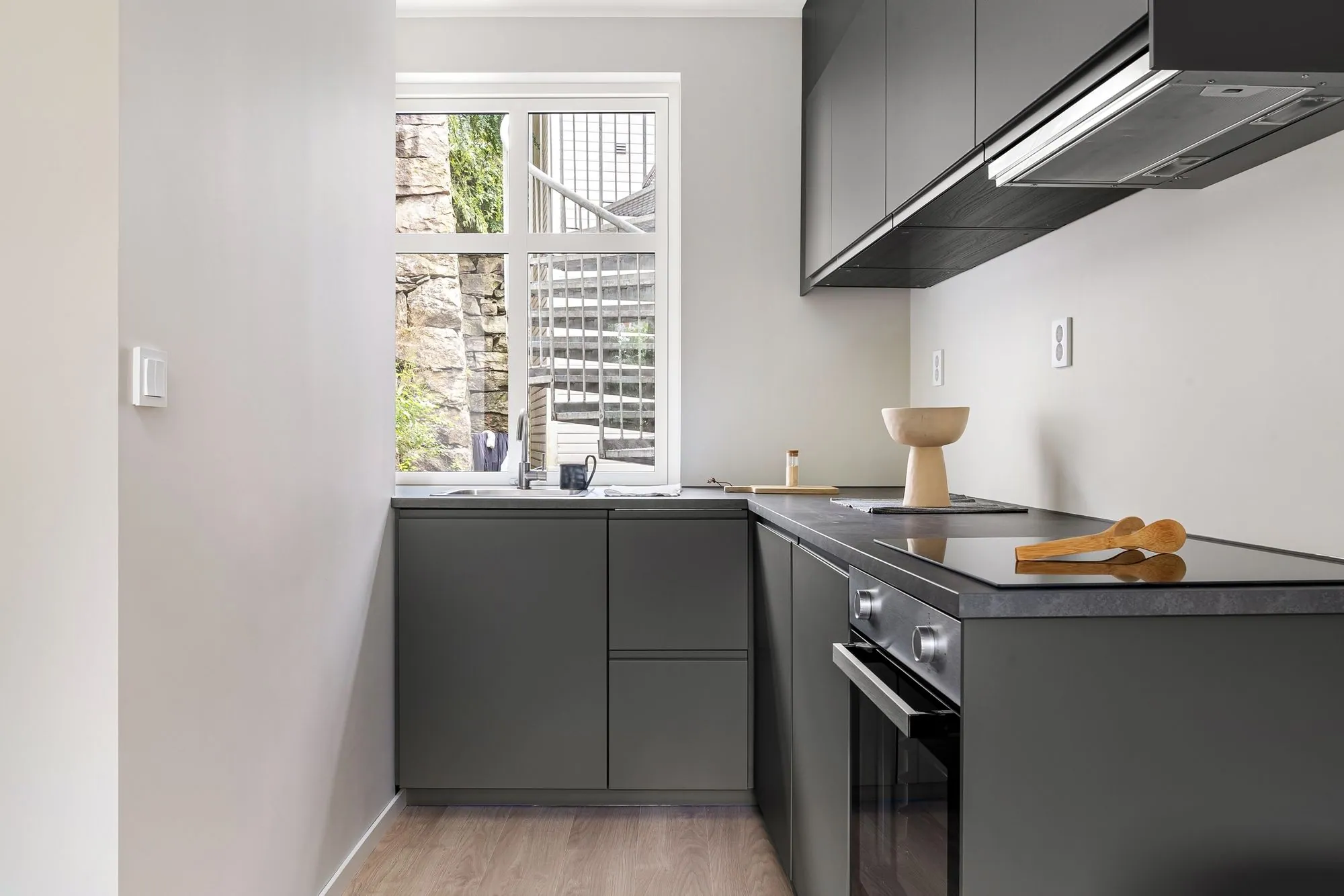 Grey handleless units in a compact galley, with an integrated hob set into a thin counter