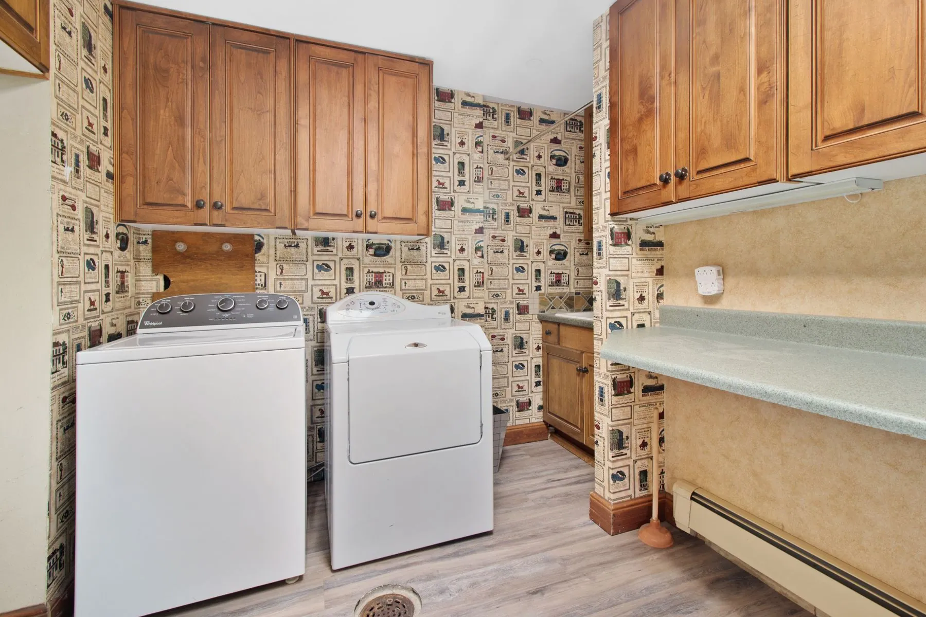 Laundry room with wall cabinets above the machines and a folding ledge running along the opposite wall
