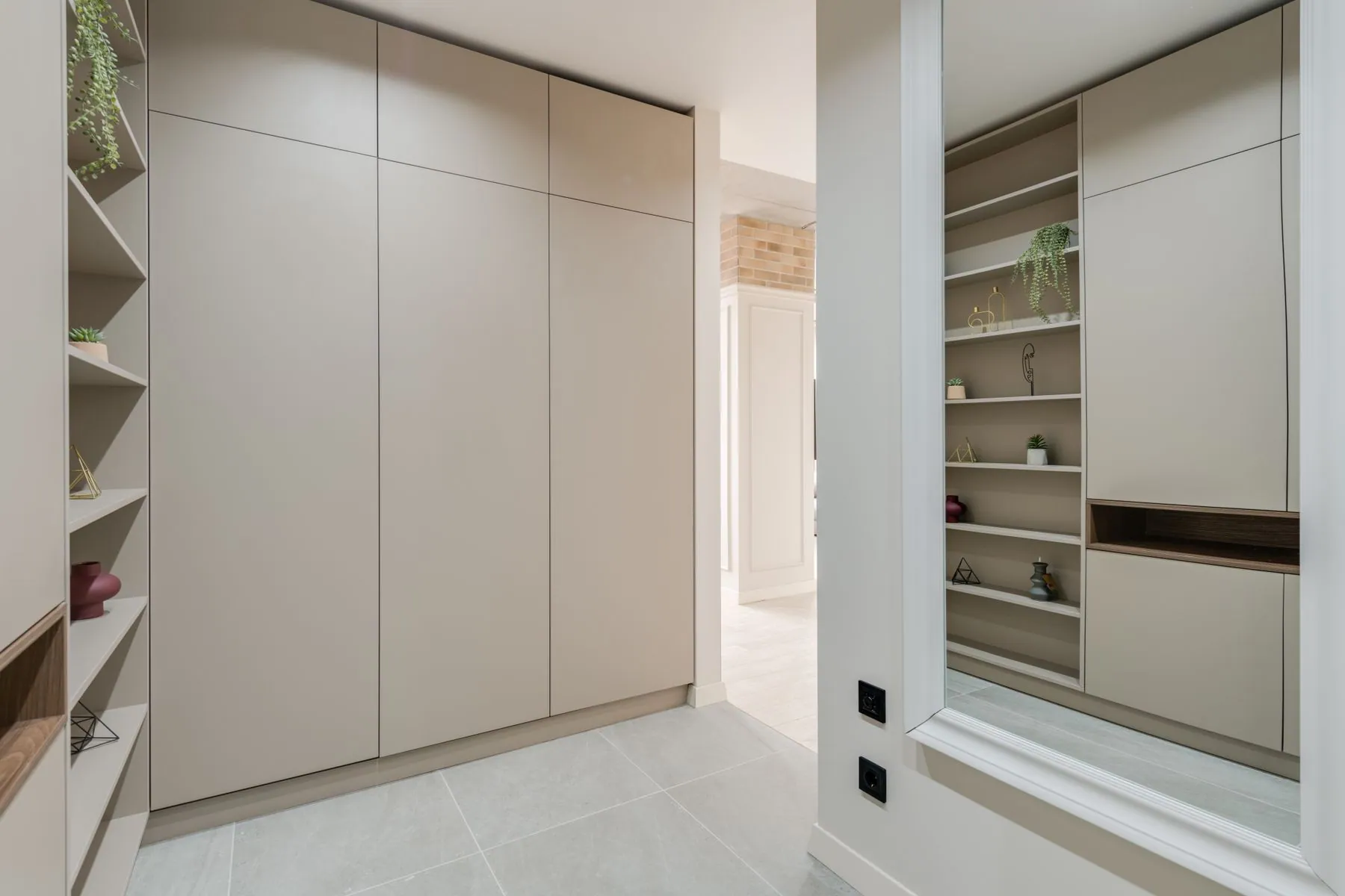 Floor-to-ceiling library in rift-cut oak veneer with adjustable shelves and LED recessed into the shelf reveals