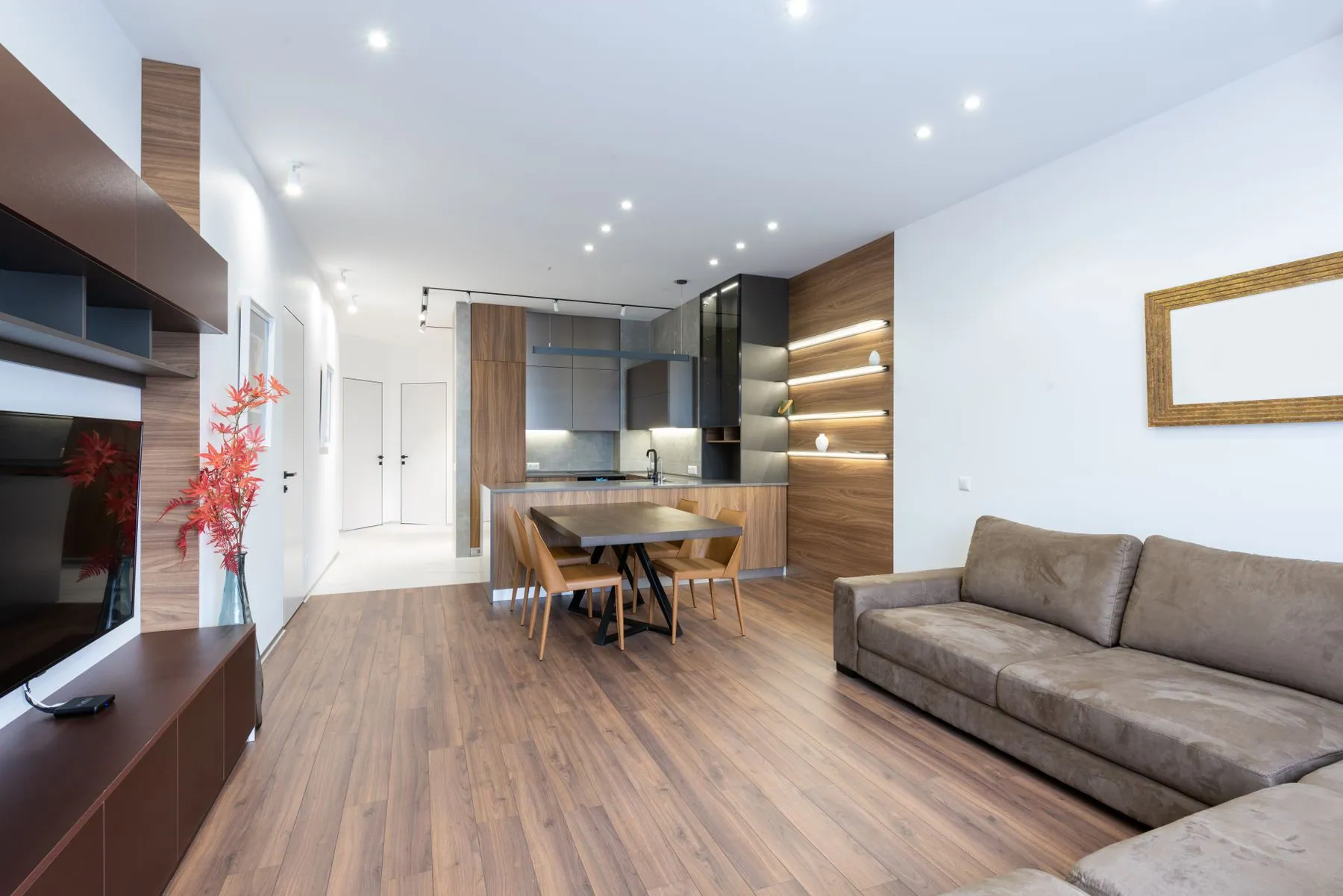 Media wall in book-matched walnut veneer with a recessed screen bay, ventilated equipment cupboards and flush push-to-open fronts