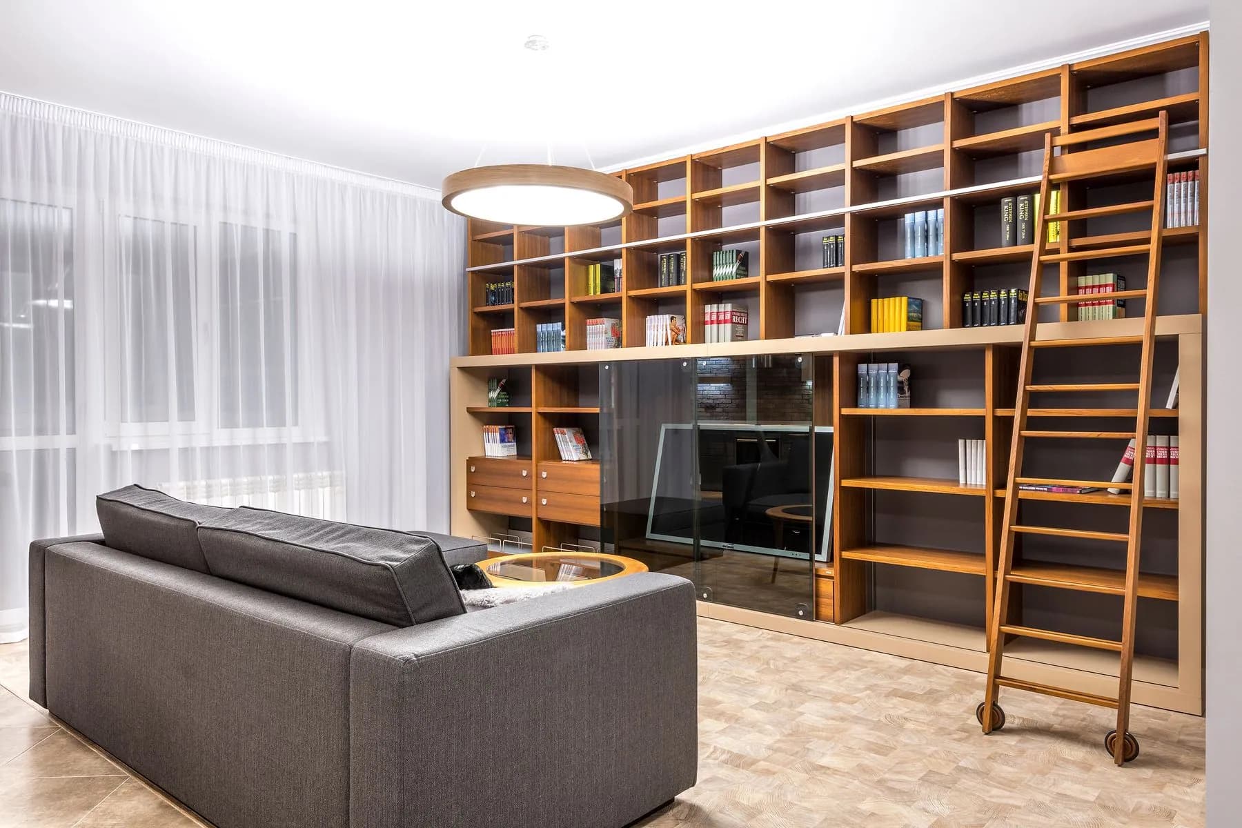 Basement media room with a full-height handleless cabinet run, subwoofer bay and dimmed cove lighting