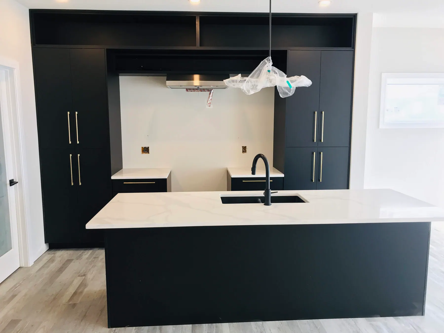 Black tall units with long vertical brass pulls
