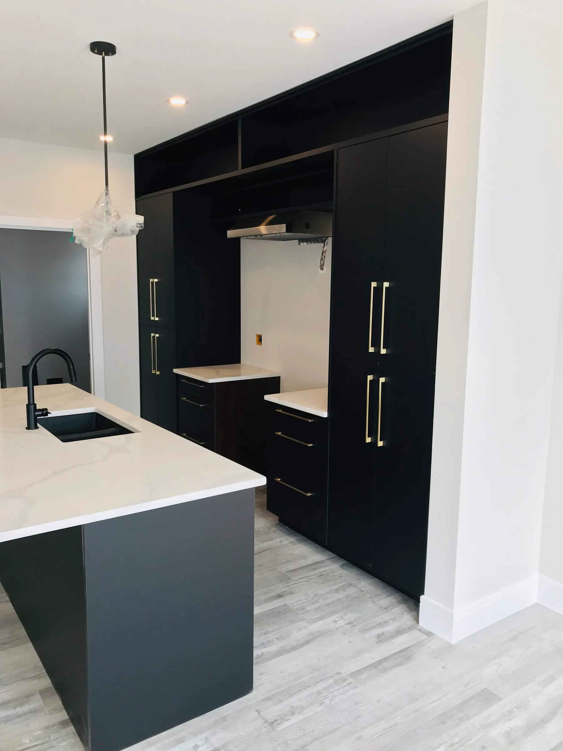 Matte black vanity set on a recessed plinth over tiled flooring