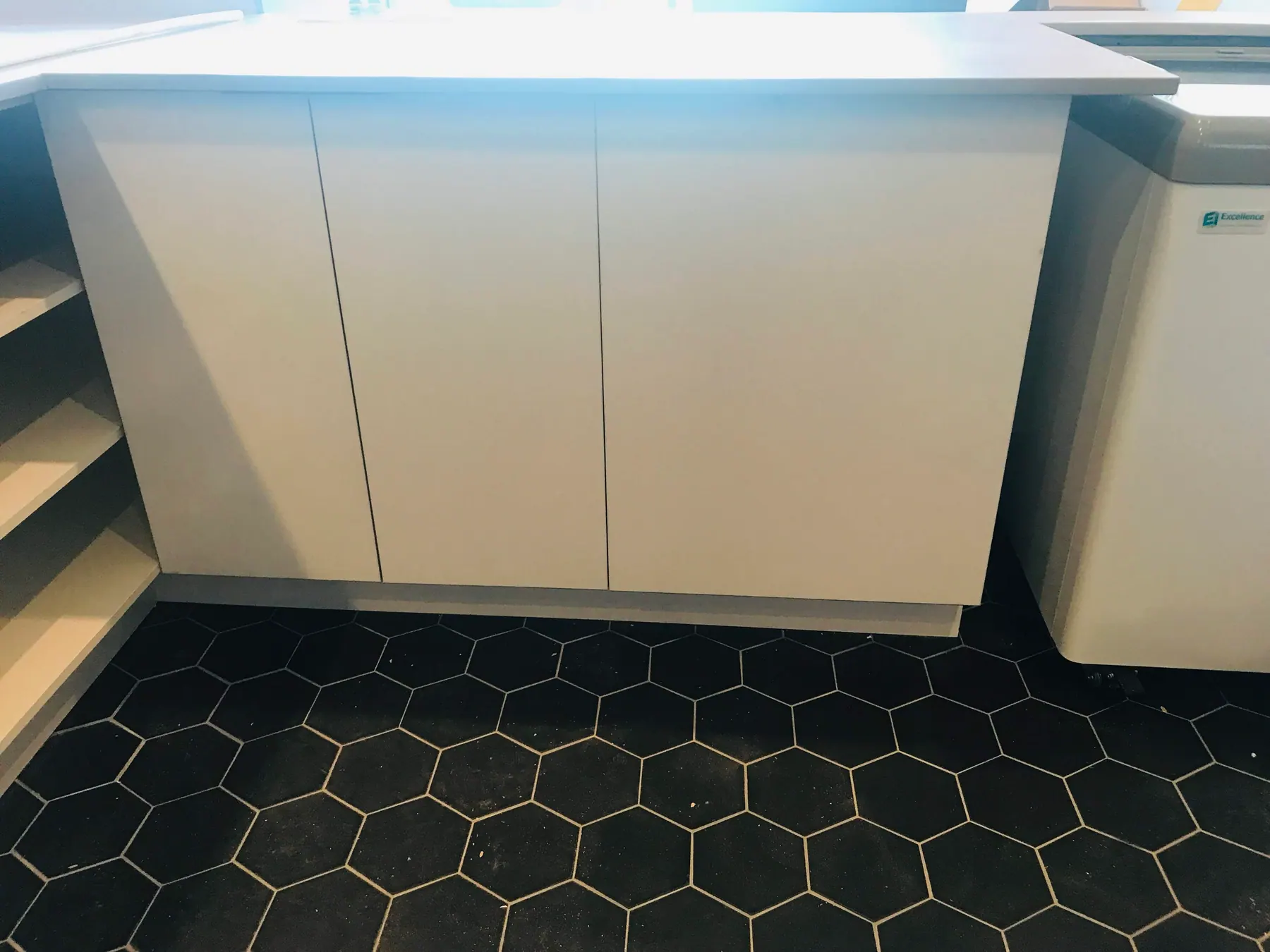 White slab counter run with flush handleless fronts