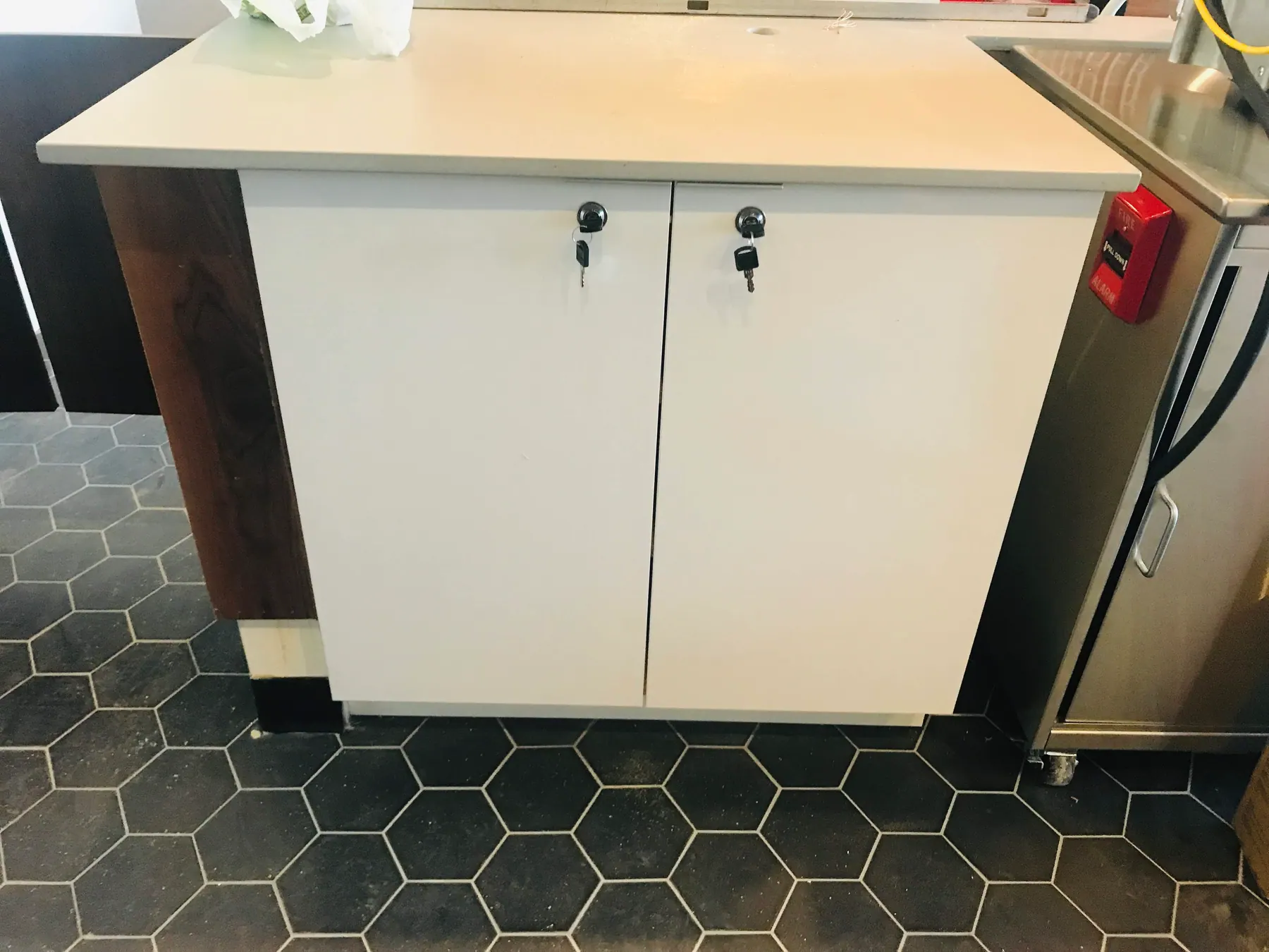Lockable walnut tall cabinet beside the white service run