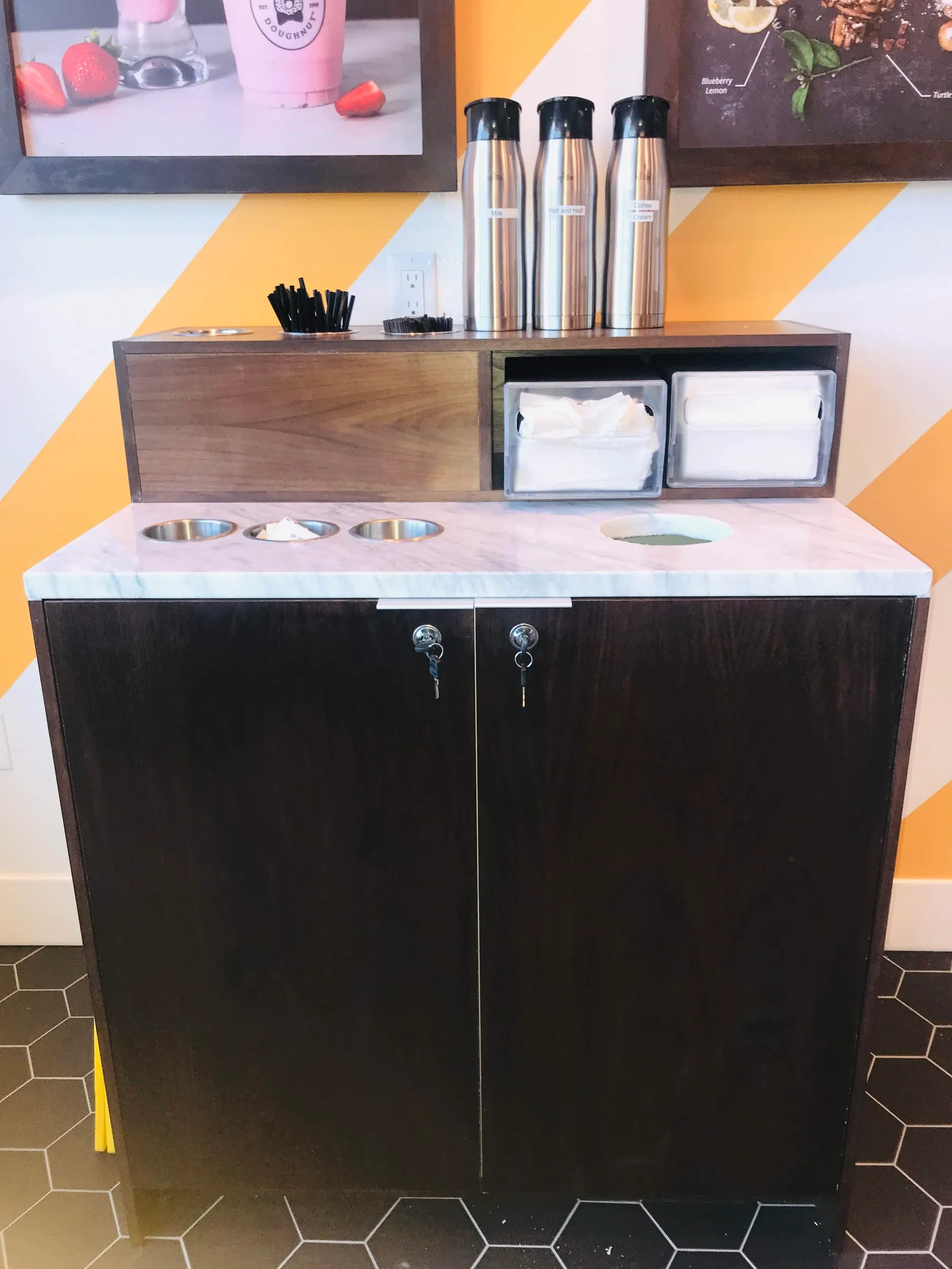 Condiment station seen against the shop signage