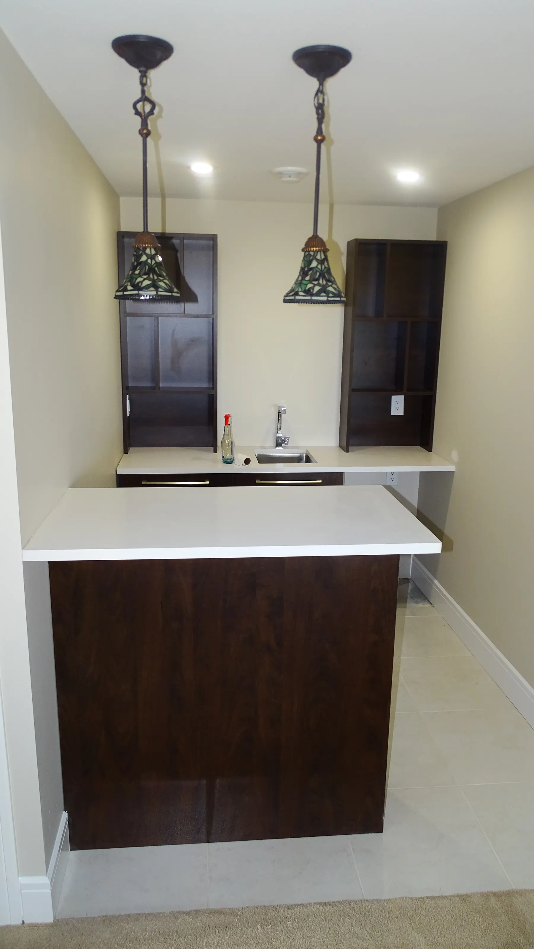Bar counter with an inset sink and a raised quartz serving ledge