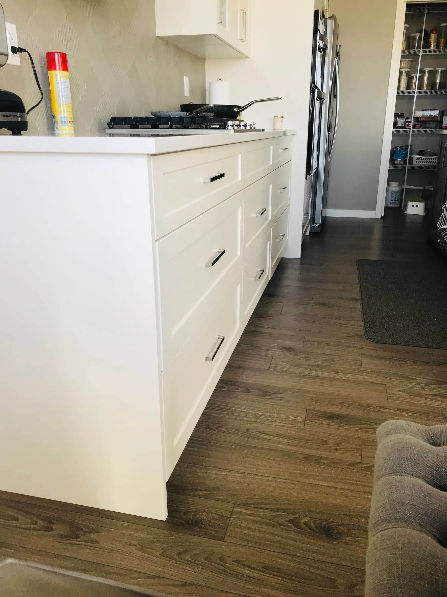White drawer bank on black pulls, set against a wood floor