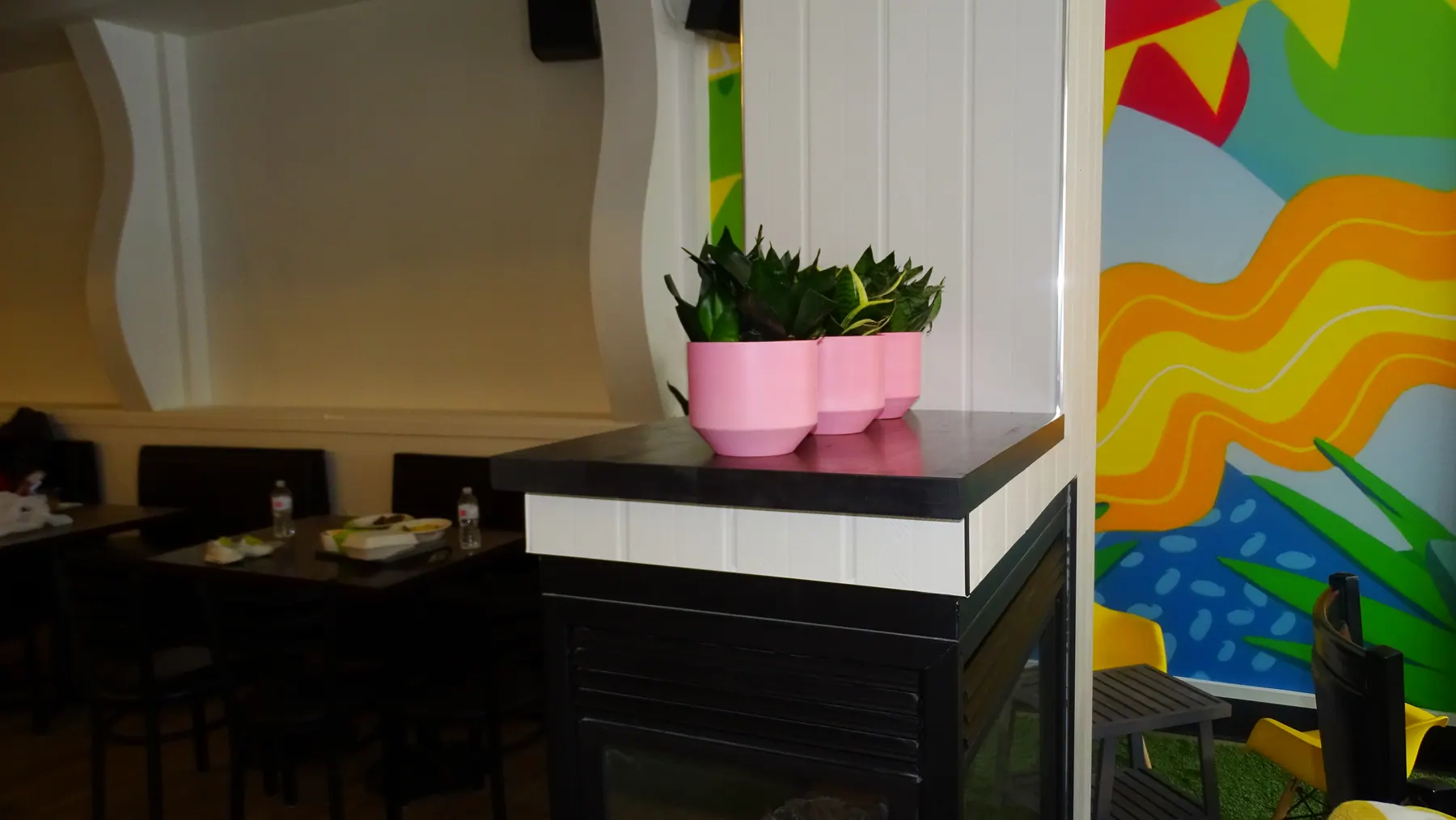 Dark-faced service counter set against the painted mural wall