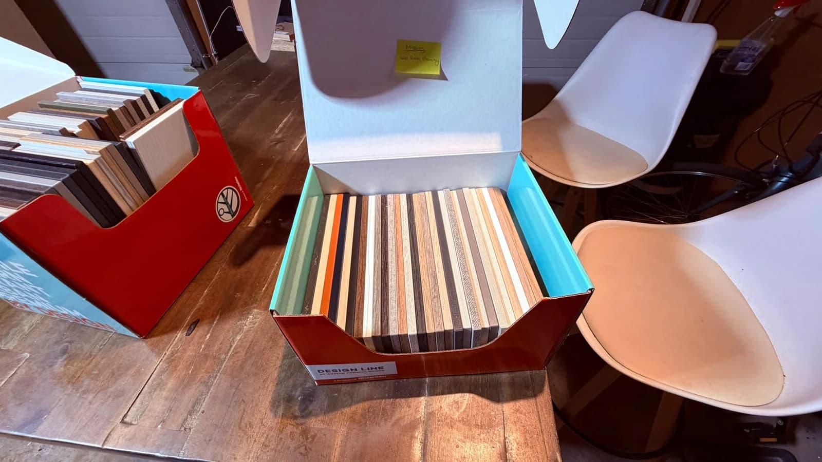 Two sample boxes open on a bench, each holding dozens of panel samples standing on edge