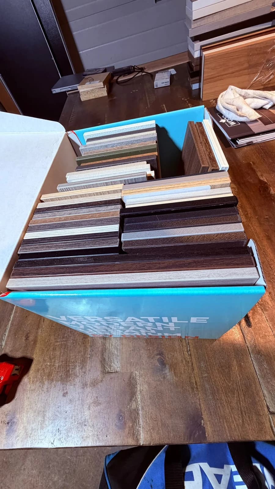 Panel samples stood on edge in their box, showing the range of wood grains, greys and greens side by side